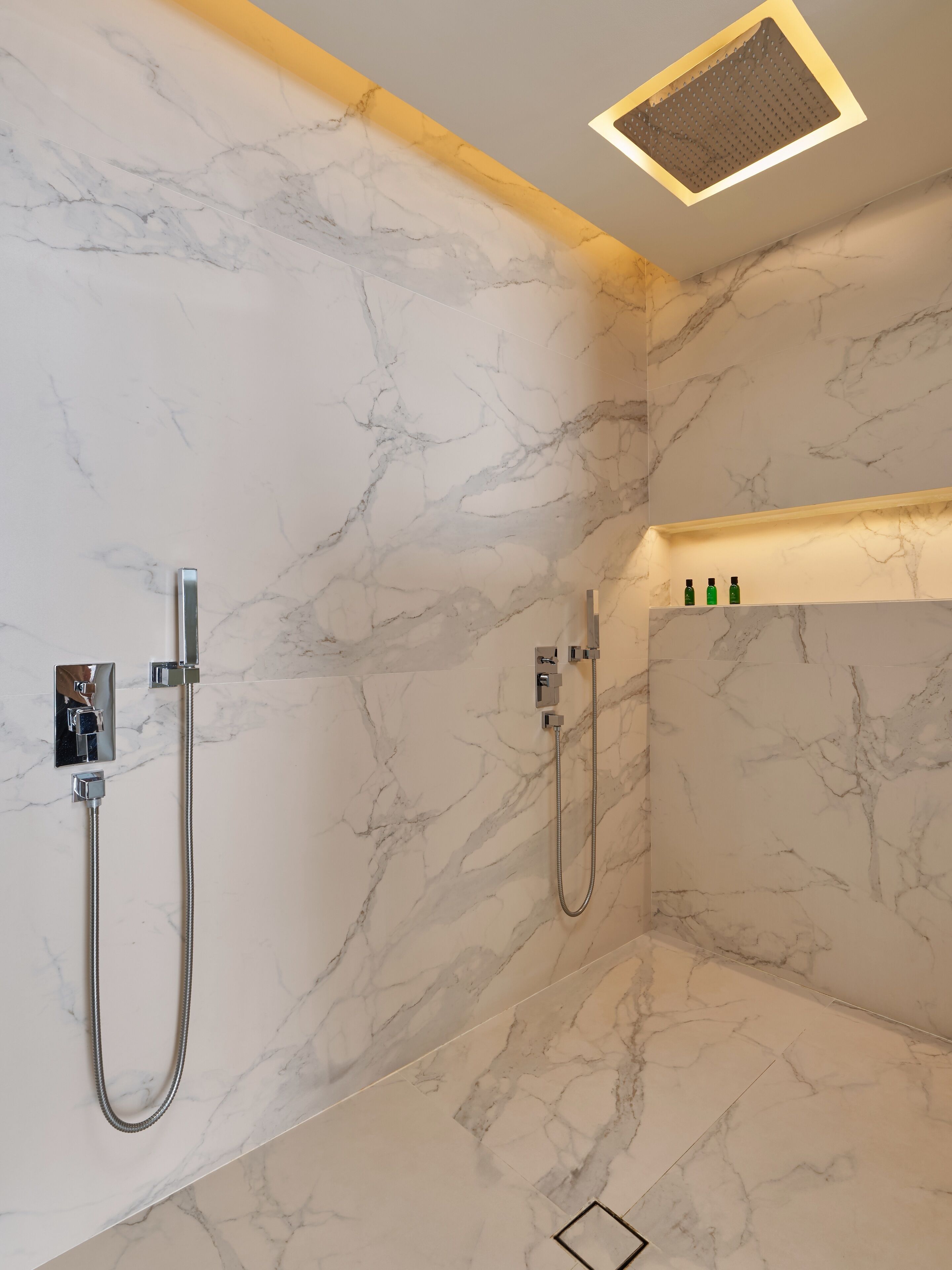 Un baño moderno con paredes de mármol y zona de ducha.