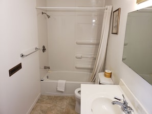 A bathroom with a bathtub, toilet, and sink.