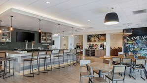 A modern bar area with a long counter, bar stools, and a television screen. - Best Western Plus Peppertree Nampa Civic Center Inn (Nampa)