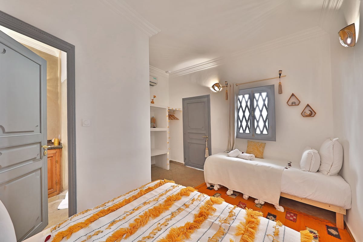 Quarto com cama, penteadeira e guarda-roupa.