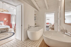 Ein modernes Badezimmer mit einer freistehenden Badewanne, einem großzügigen Waschbecken und einer Duschkabine.