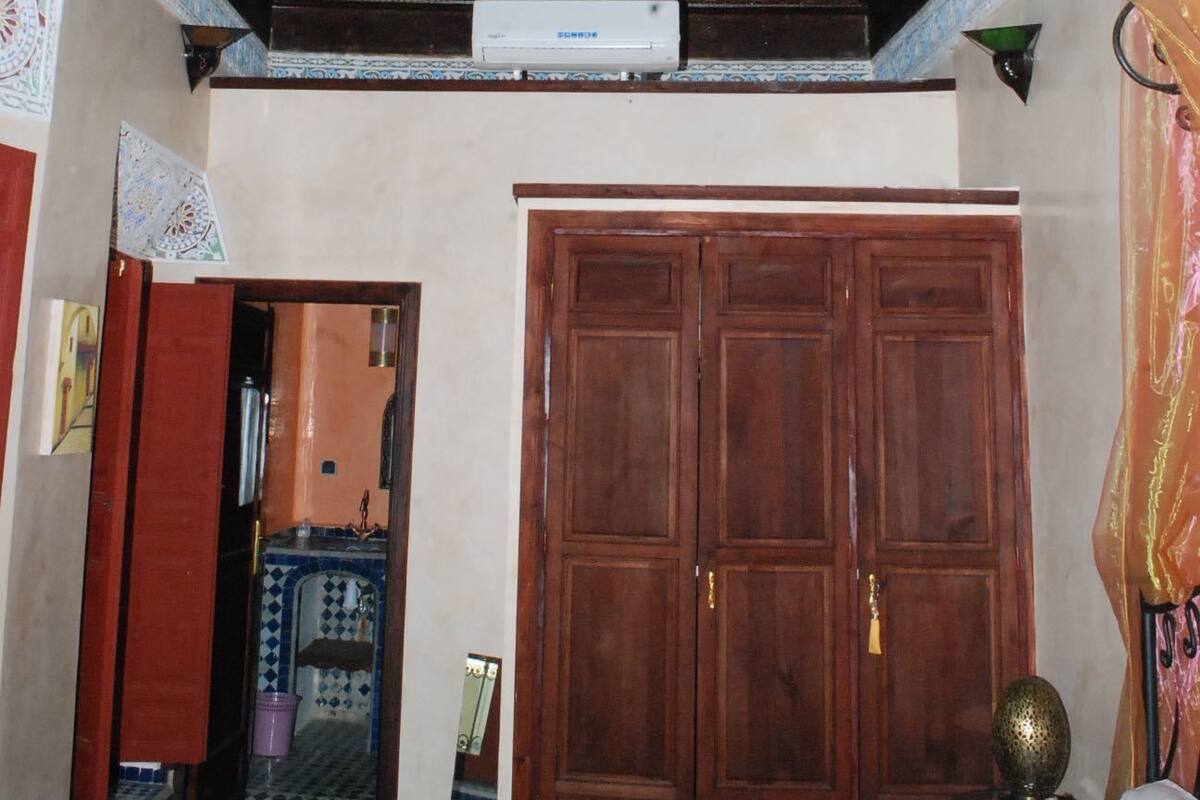 Une pièce avec un plafond en bois, une grande armoire et un sol carrelé.