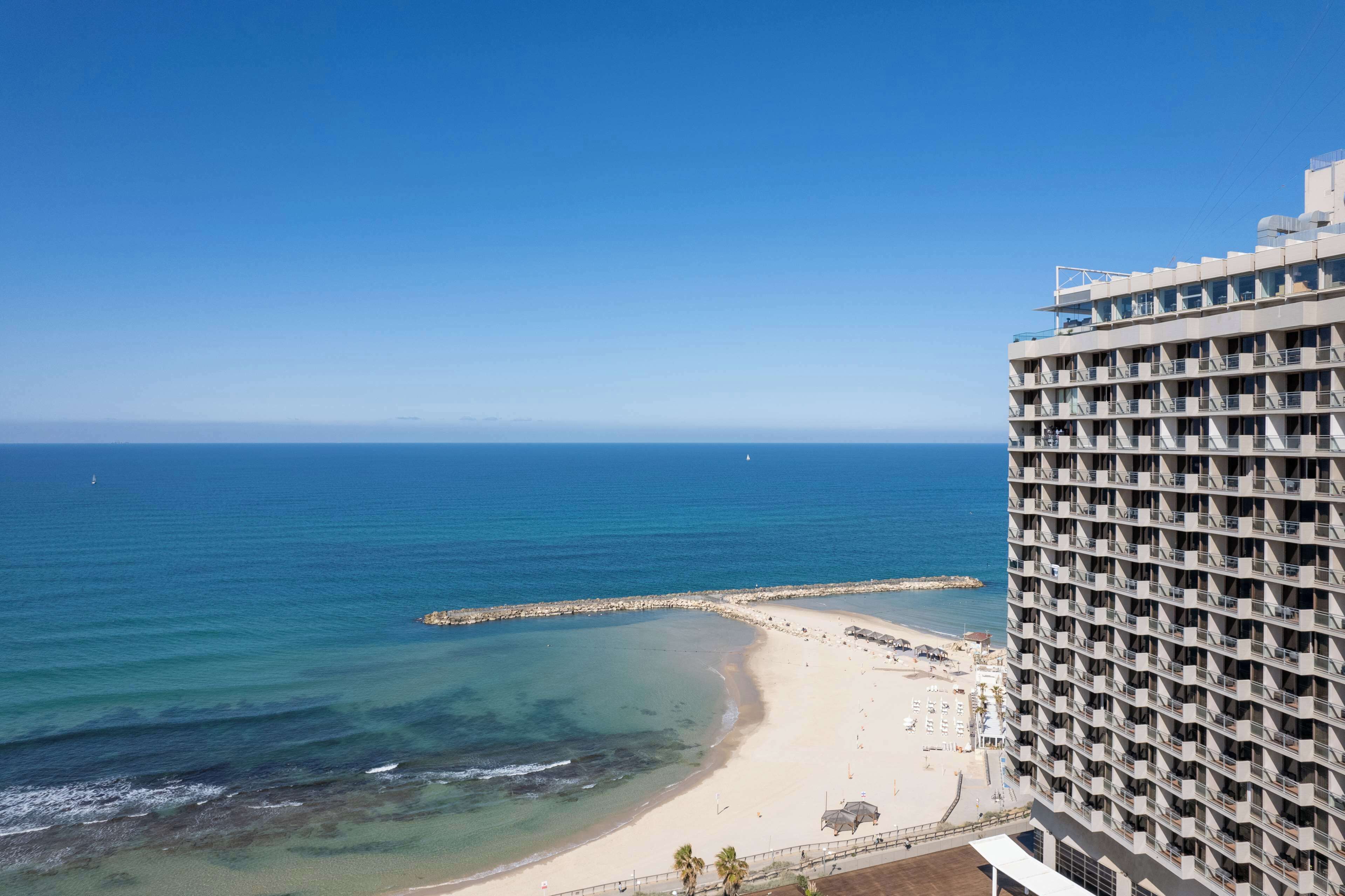Un hotel moderno con varios balcones que dan a la playa y al océano.
