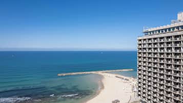 Un hotel moderno con varios balcones que dan a la playa y al océano.