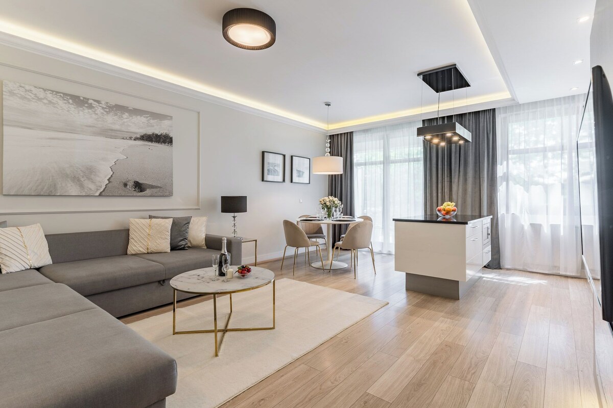A modern living room with a sofa, coffee table, and dining area.