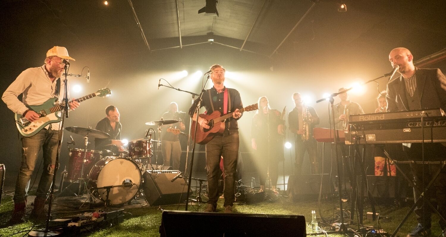 A band performing on a stage with musical instruments and equipment.