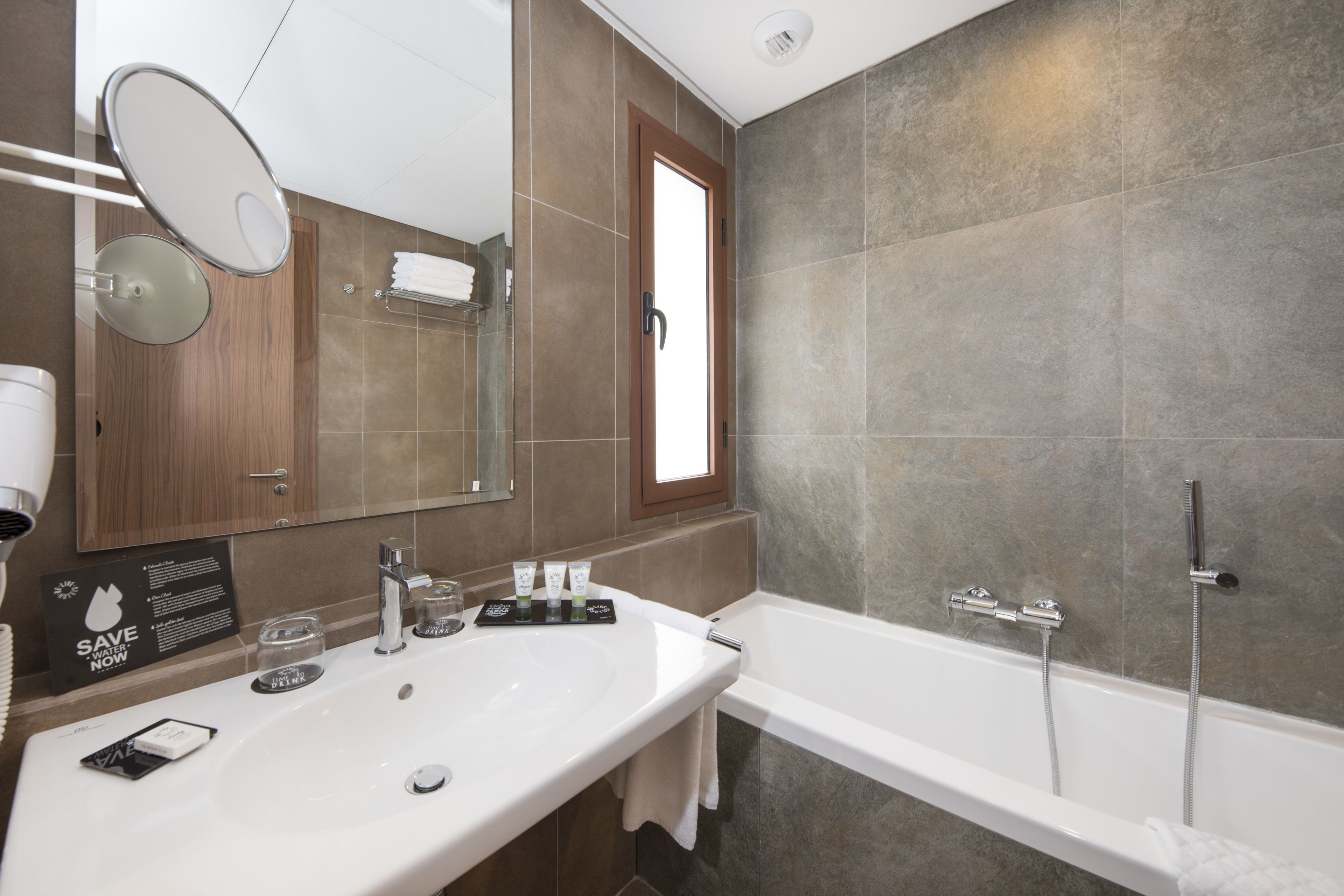 Un baño moderno con un lavamanos grande, espejo y ducha a pie.