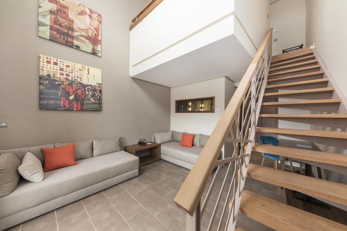 A modern living room with a sofa, a coffee table, and a staircase.