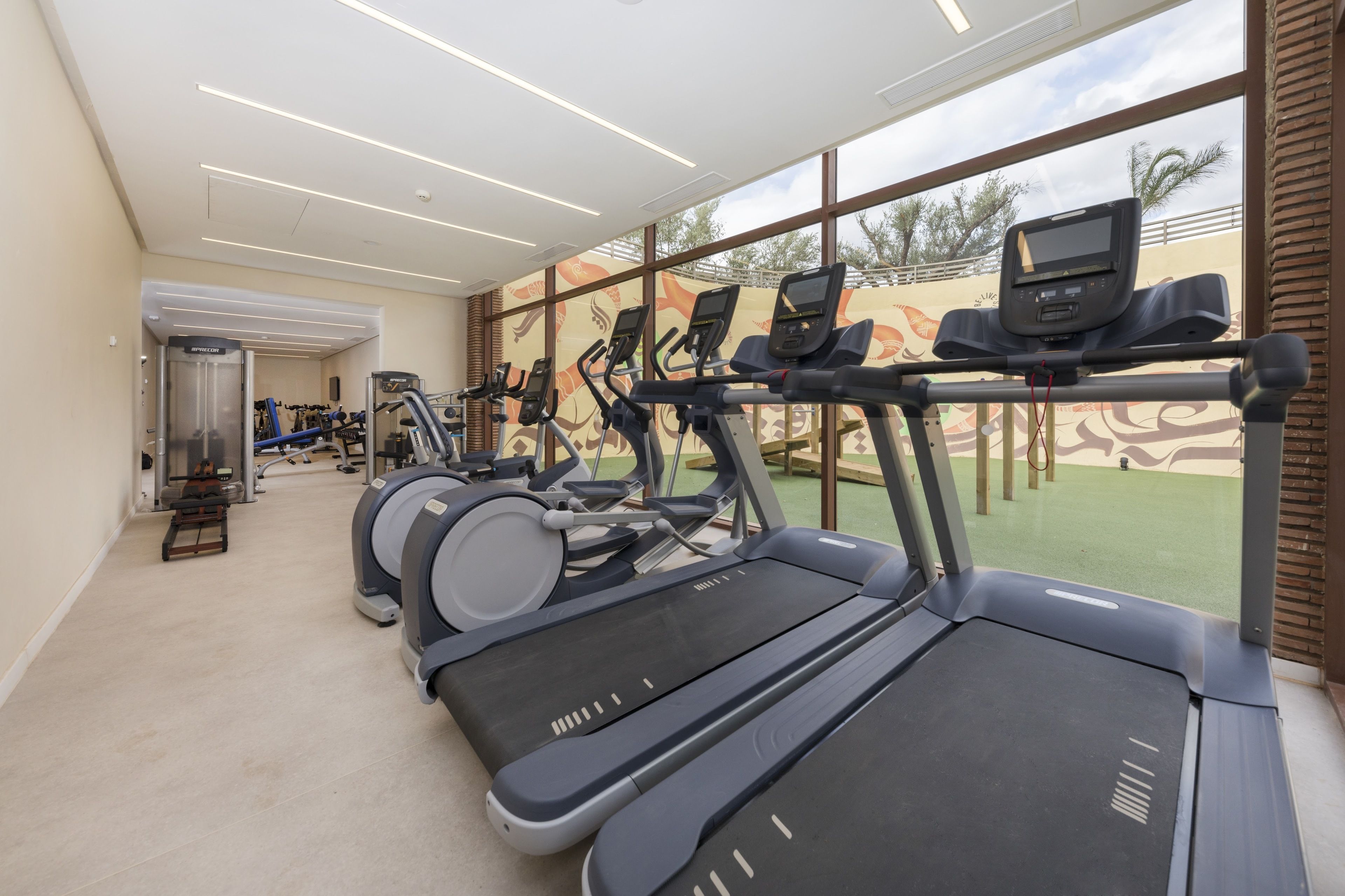 A gym with treadmills, stationary bikes, and a rowing machine.