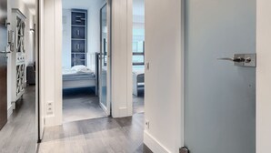 A modern bedroom with a bed, built-in wardrobe, and a view through an open door. - Imperial Apartments - Aquarius (Sopot)
