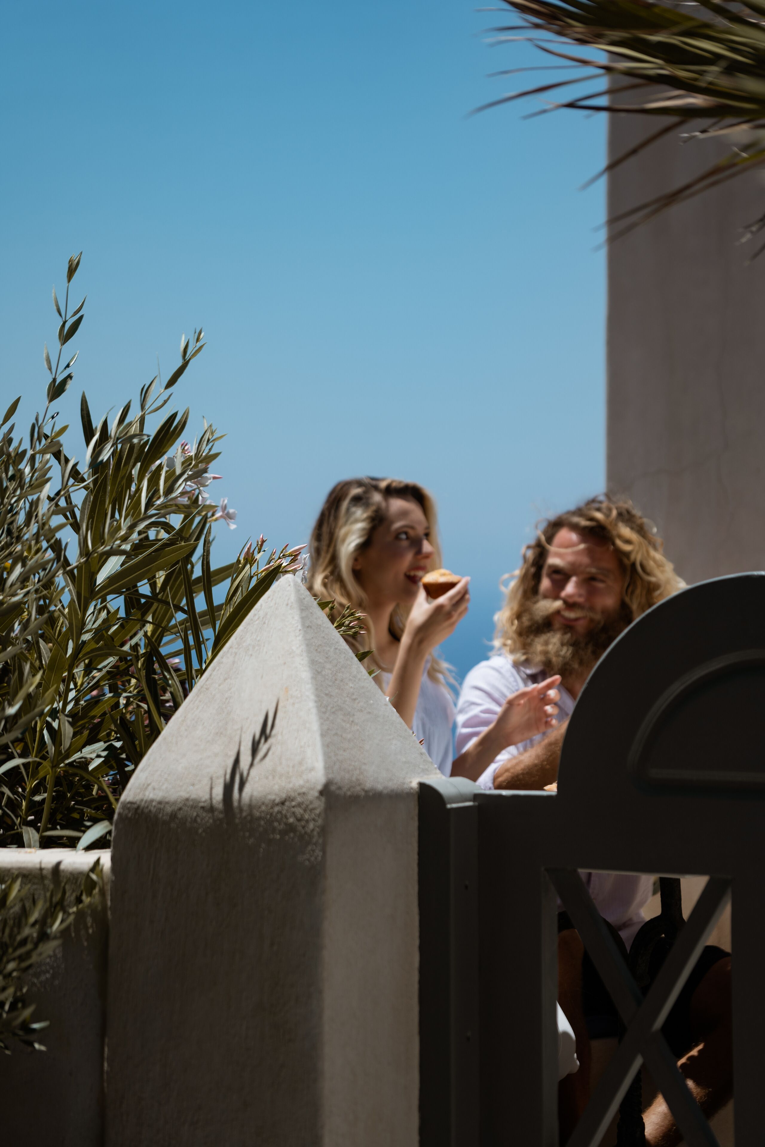 A man and a woman sitting outside, eating.