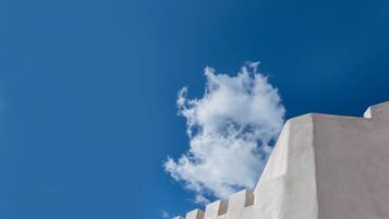 A white building with a flat roof and a clear blue sky in the background.