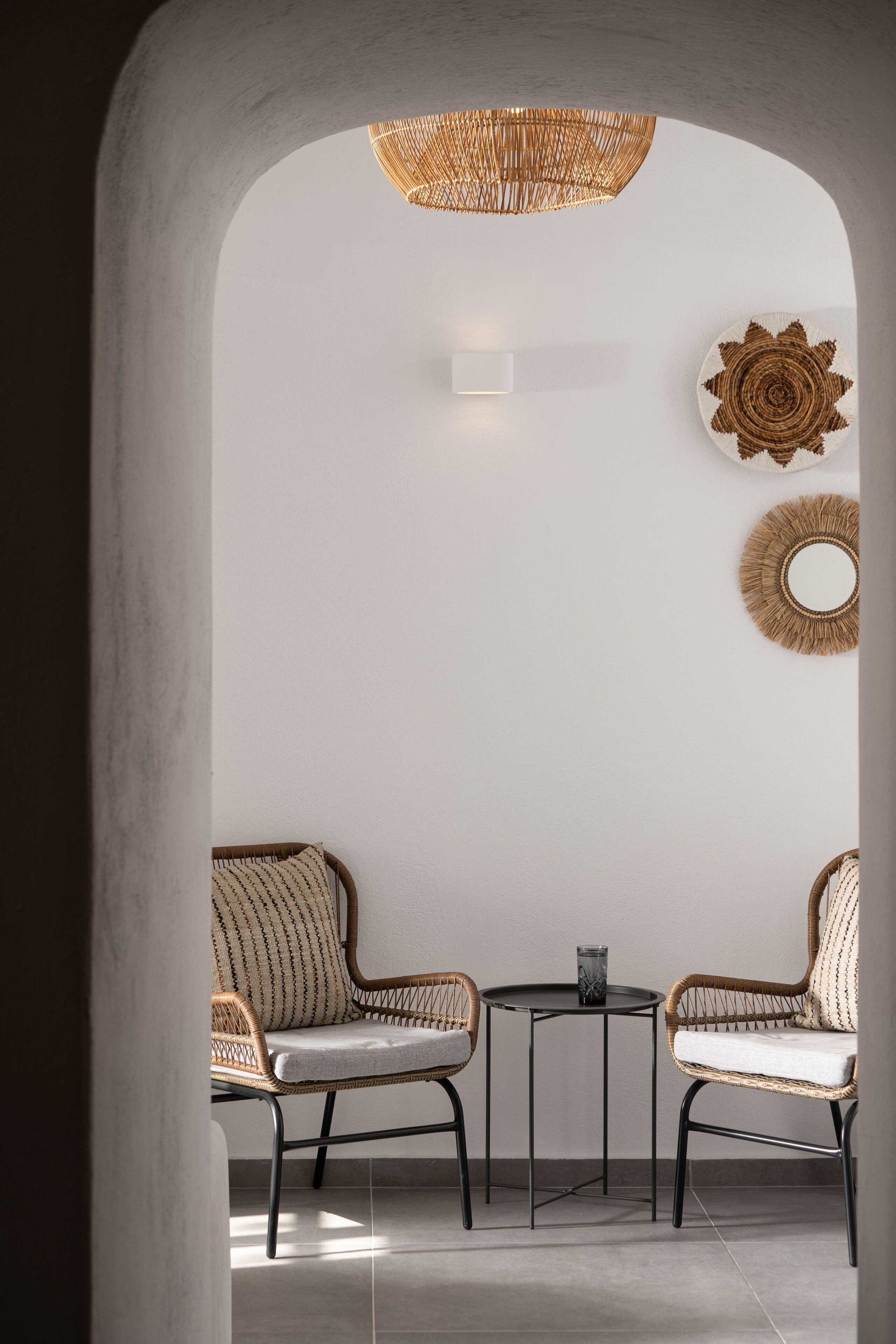 A modern interior with two wicker chairs, a small round table, and decorative wall art.
