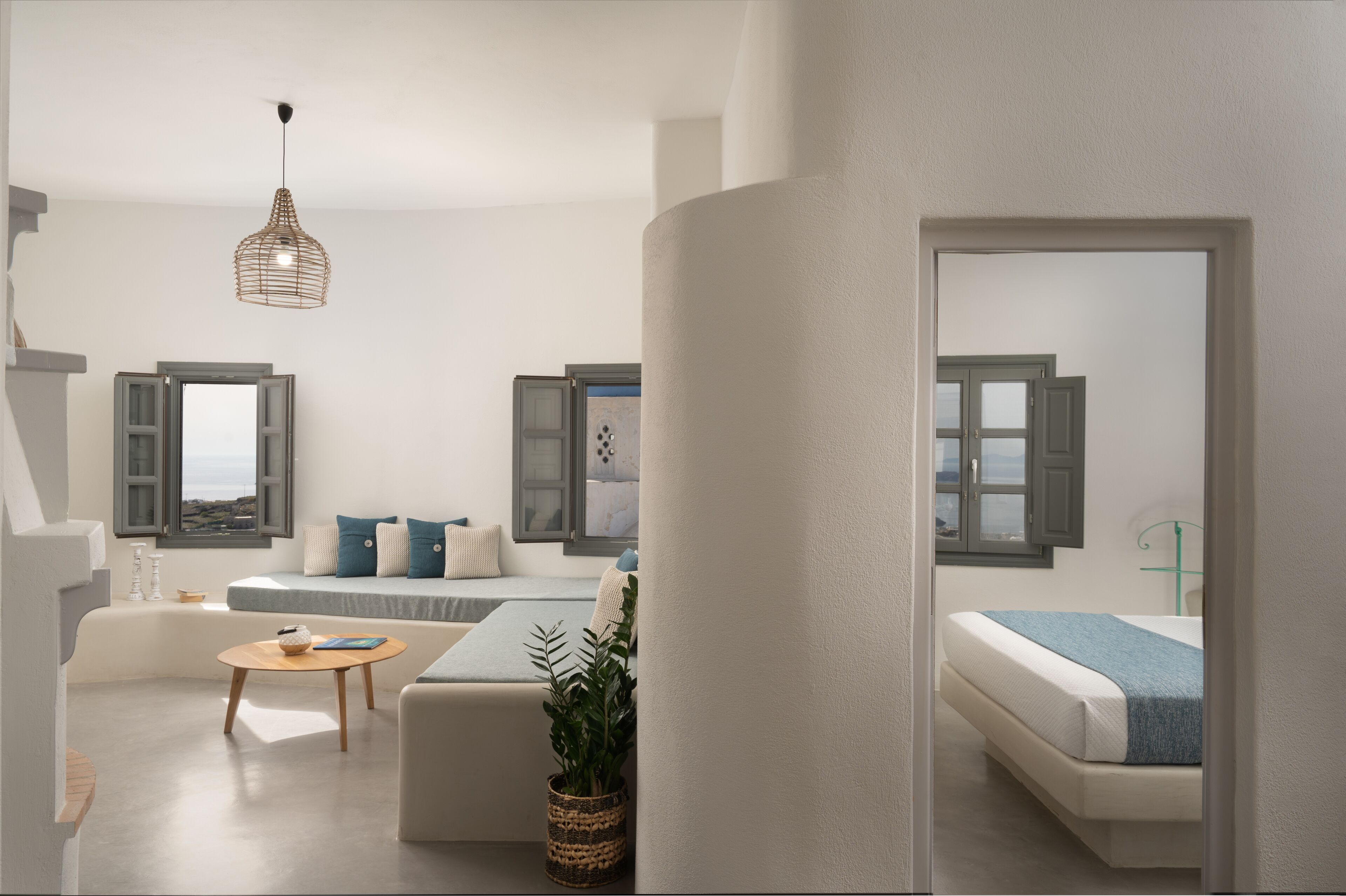A modern, well-lit living room with a sofa, a coffee table, and a hanging light fixture.