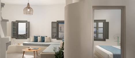 A modern, well-lit living room with a sofa, a coffee table, and a hanging light fixture.