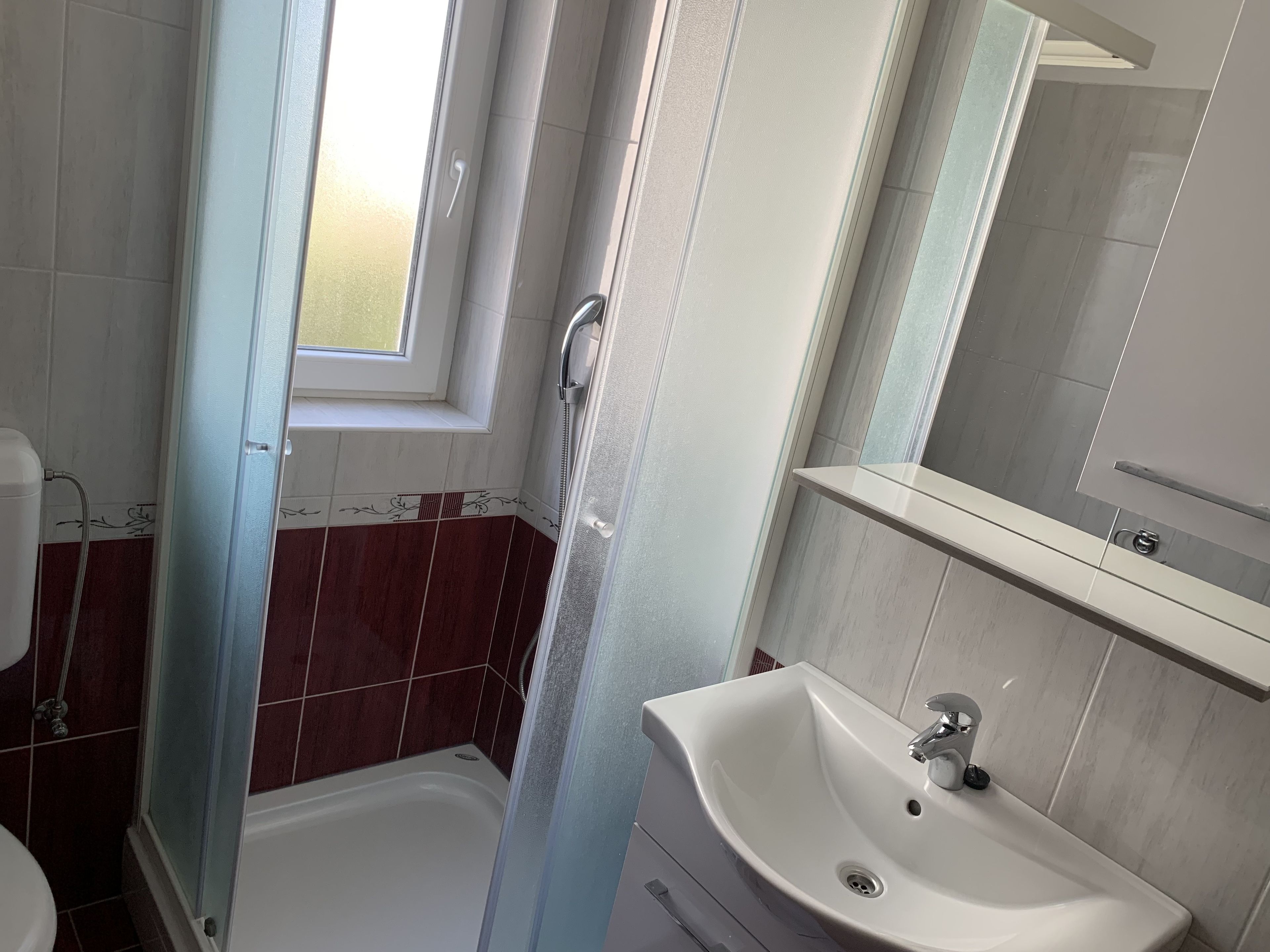 Ein Badezimmer mit Dusche, Waschbecken und Toilette.