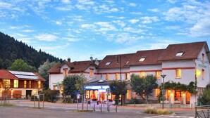 Un hotel con una hilera de habitaciones, un restaurante y un estacionamiento.