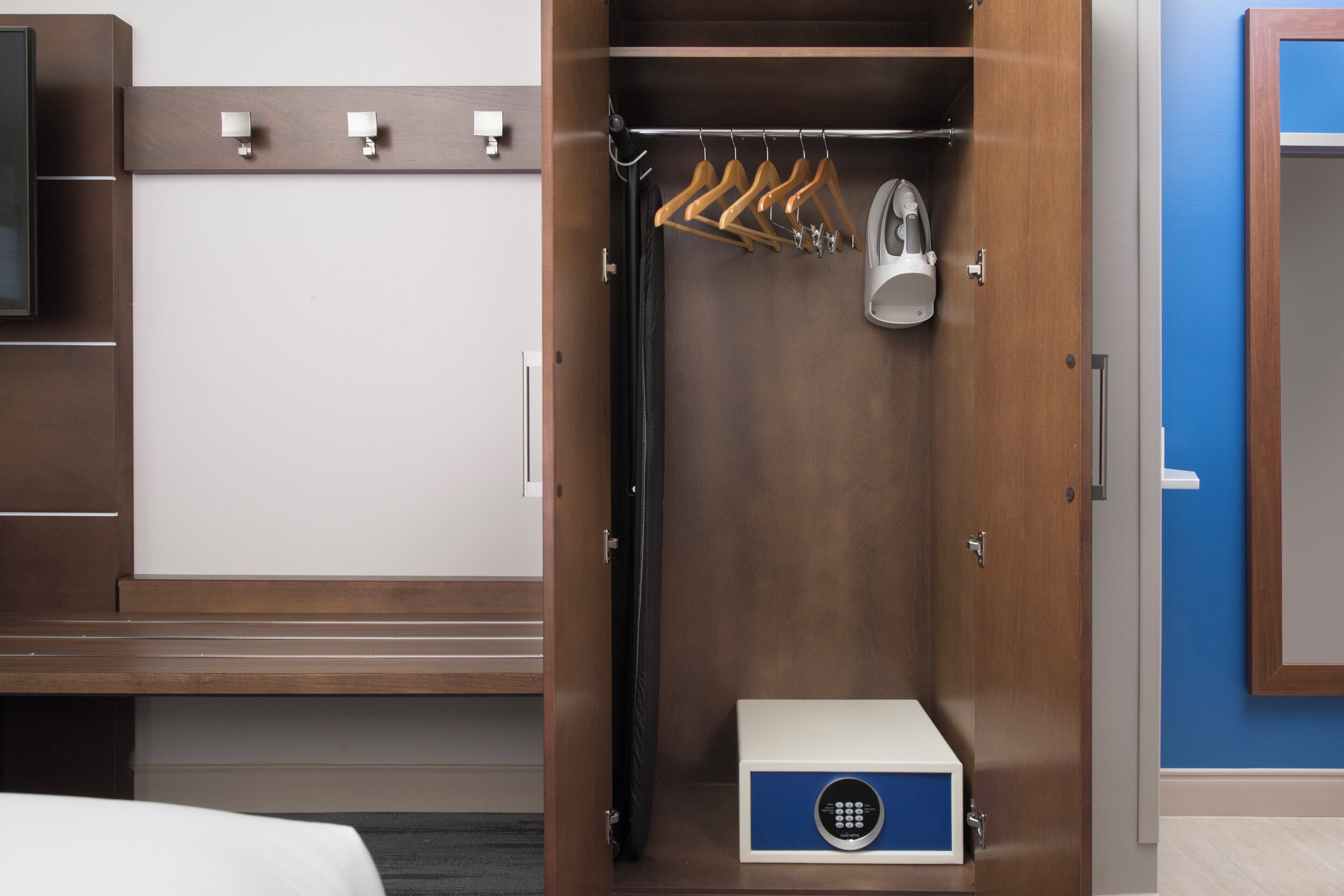 A walk-in closet with a hanging rack, a shoe shine machine, and a storage box.