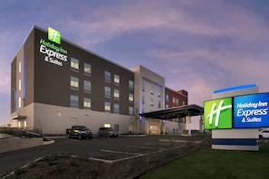 Ein Holiday Inn Express & Suites Hotel mit Parkplatz und überdachtem Zugang.