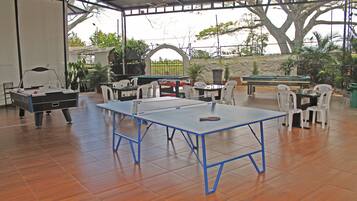 Enjoy games and leisure time in this indoor recreational area featuring a ping pong table, pool table, and comfortable seating.