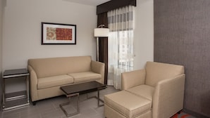A modern living room with a sofa, armchair, and a small table. - Holiday Inn Express Springfield Downtown by IHG (Springfield)
