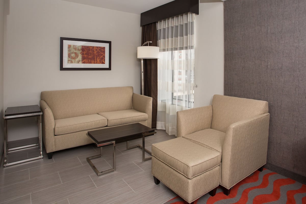 A modern living room with a sofa, armchair, and a small table.