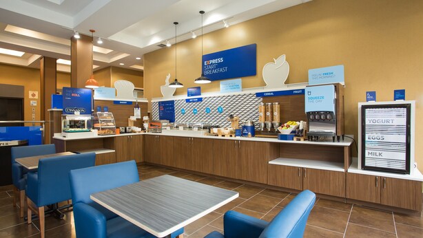 A breakfast area with a counter, seating, and a menu display. - Holiday Inn Express Springfield Downtown by IHG (Springfield)