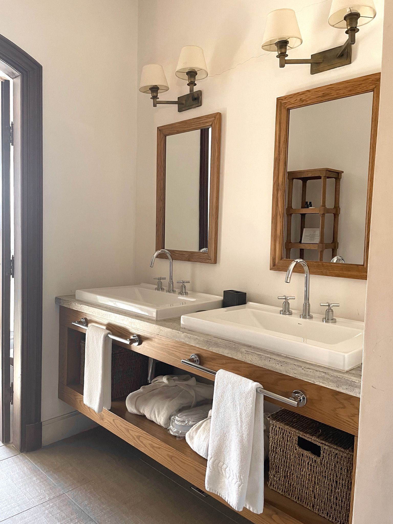Un baño con dos lavamanos, un espejo y un perchero para toallas.