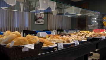 A buffet with various breads and pastries.