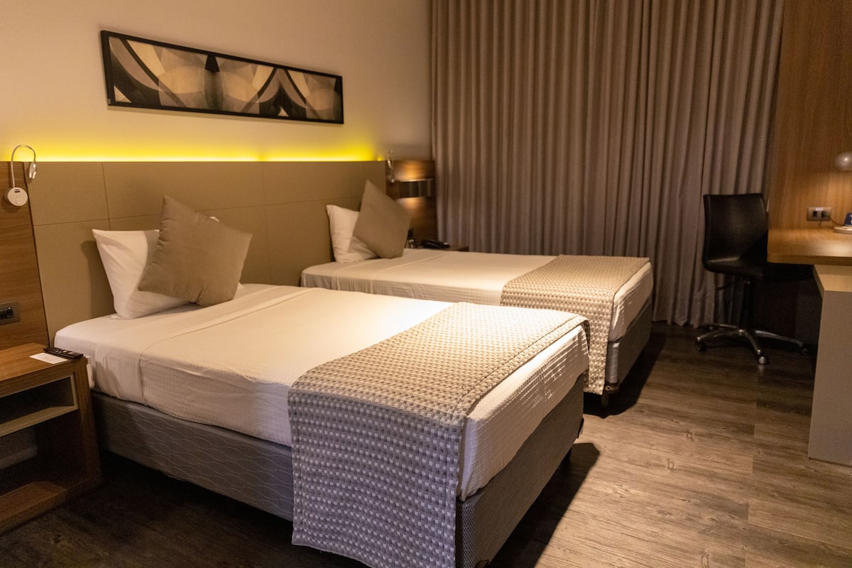 Una habitación de hotel con dos camas, un escritorio y una silla.