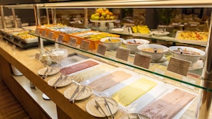 Un bufé con diferentes opciones de comida y utensilios.