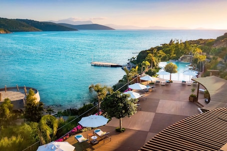 Una piscina techada, una piscina al aire libre, sombrillas. Le Méridien Bodrum Beach Resort