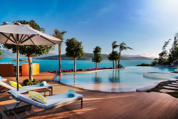 Piscine couverte, piscine extérieure, parasols de plage, chaises longues