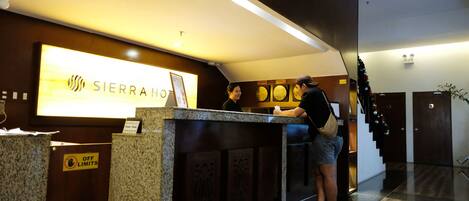 A hotel reception desk with a sign reading "SIERRAHO" and a "No Off Limits" sign.