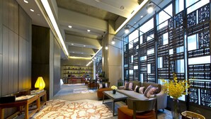 A spacious lobby with a modern design, featuring a seating area with a sofa and chairs, a coffee table, and a decorative lamp. - Wanchai 88 Hotel (Hong Kong)