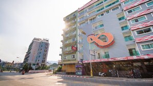 A multi-story hotel with a prominent infinity symbol logo on the facade.