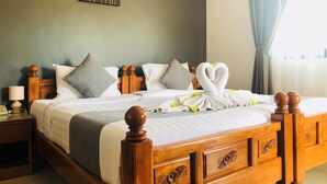 A neatly made bed with a wooden headboard, a bedside table with a lamp, and a painting on the wall.