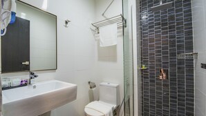 A modern bathroom with a white sink, toilet, and glass shower enclosure. - InHotel Inanam Kota Kinabalu (Kota Kinabalu)