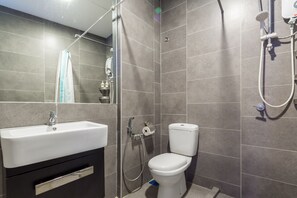 A modern bathroom with a white sink, toilet, and shower. - Luzzeri Suite Empire Damansara (Petaling Jaya)