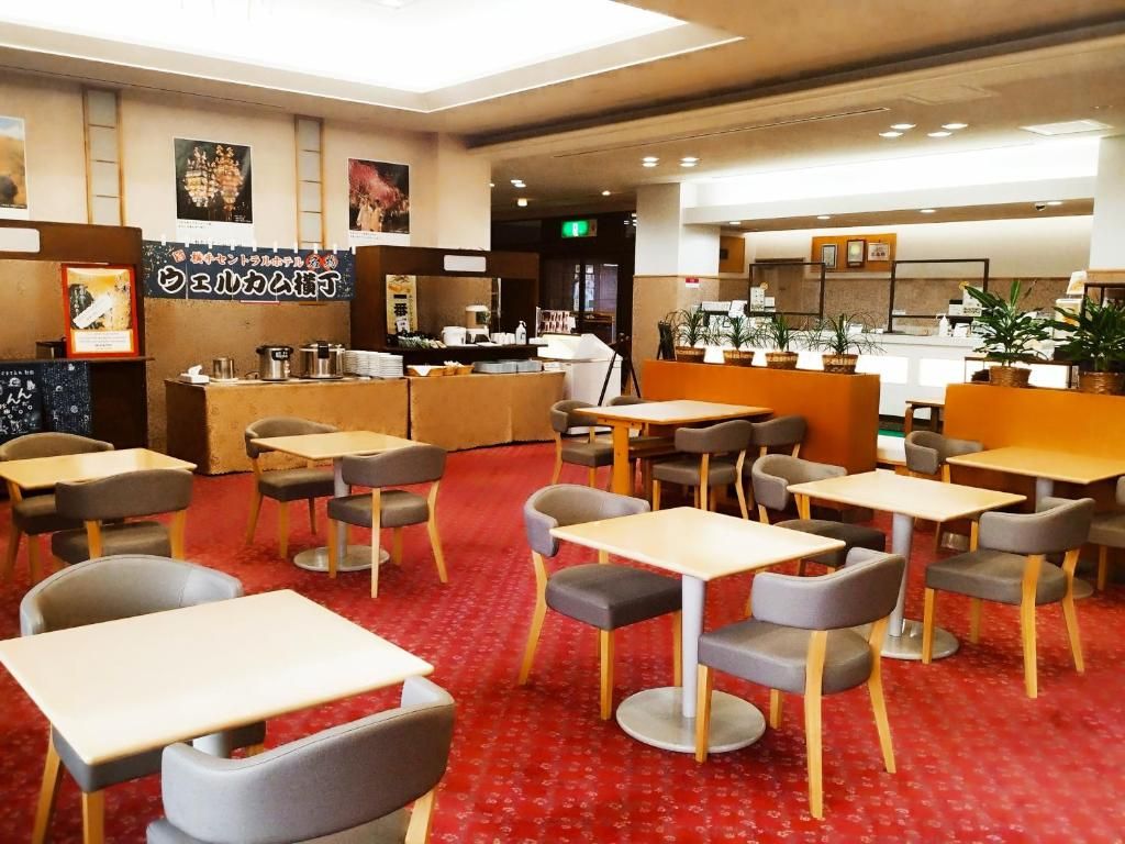Un restaurante con cabinas y mesas, una barra con el menú, y plantas en macetas.