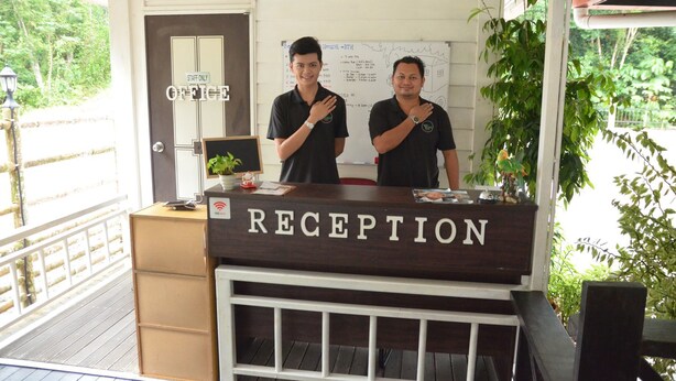 A reception desk with a sign reading "RECEPTION" and a "STAFF ONLY" sign above the door. - Borneo Tree House (Kota Kinabalu)