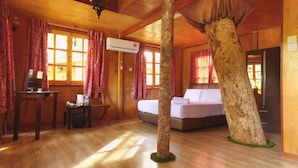 A room with wooden walls and floors, a bed, a desk with a computer, and an air conditioning unit. - Borneo Tree House (Kota Kinabalu)