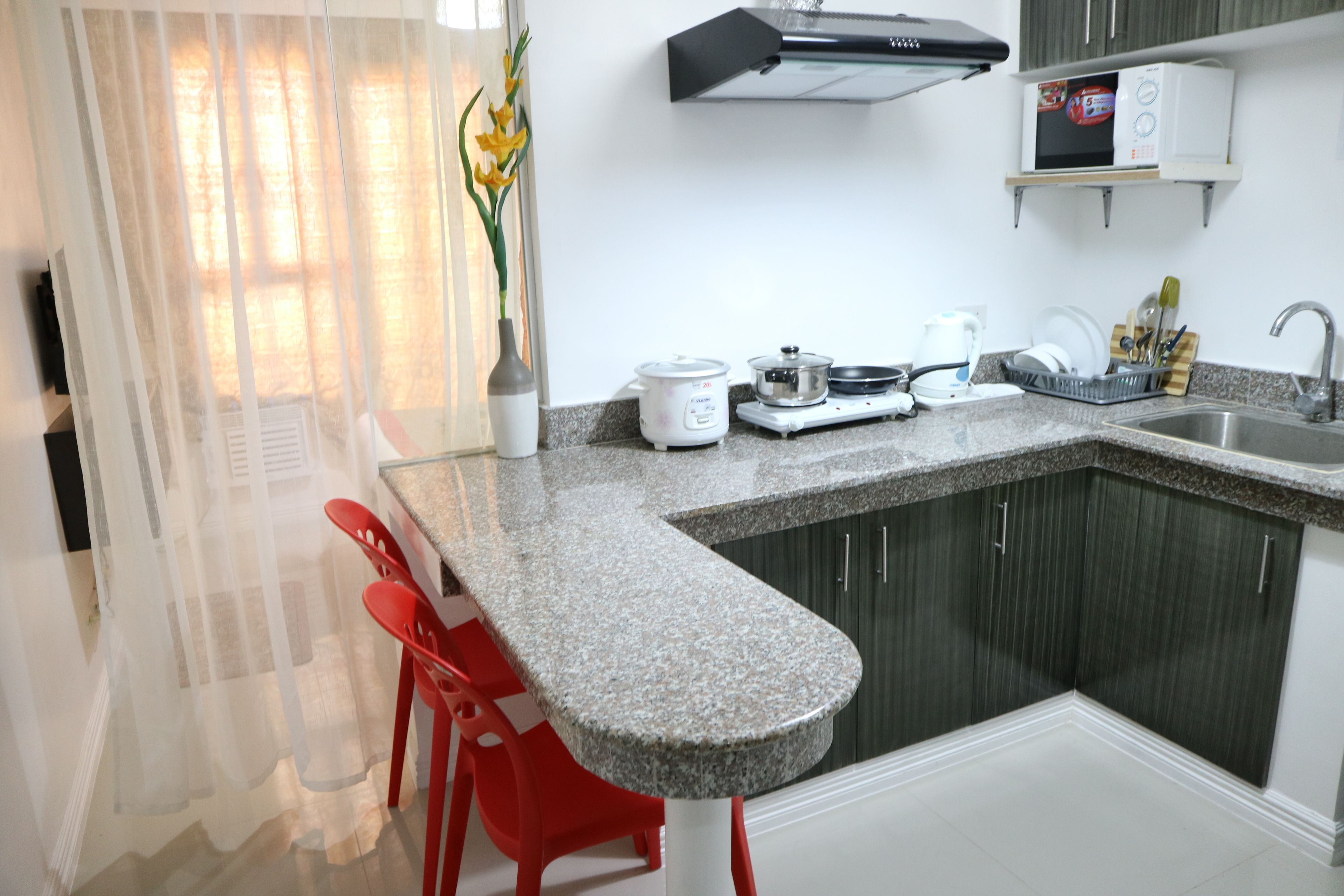 A kitchen with granite countertops, a microwave, a stove, and a sink.