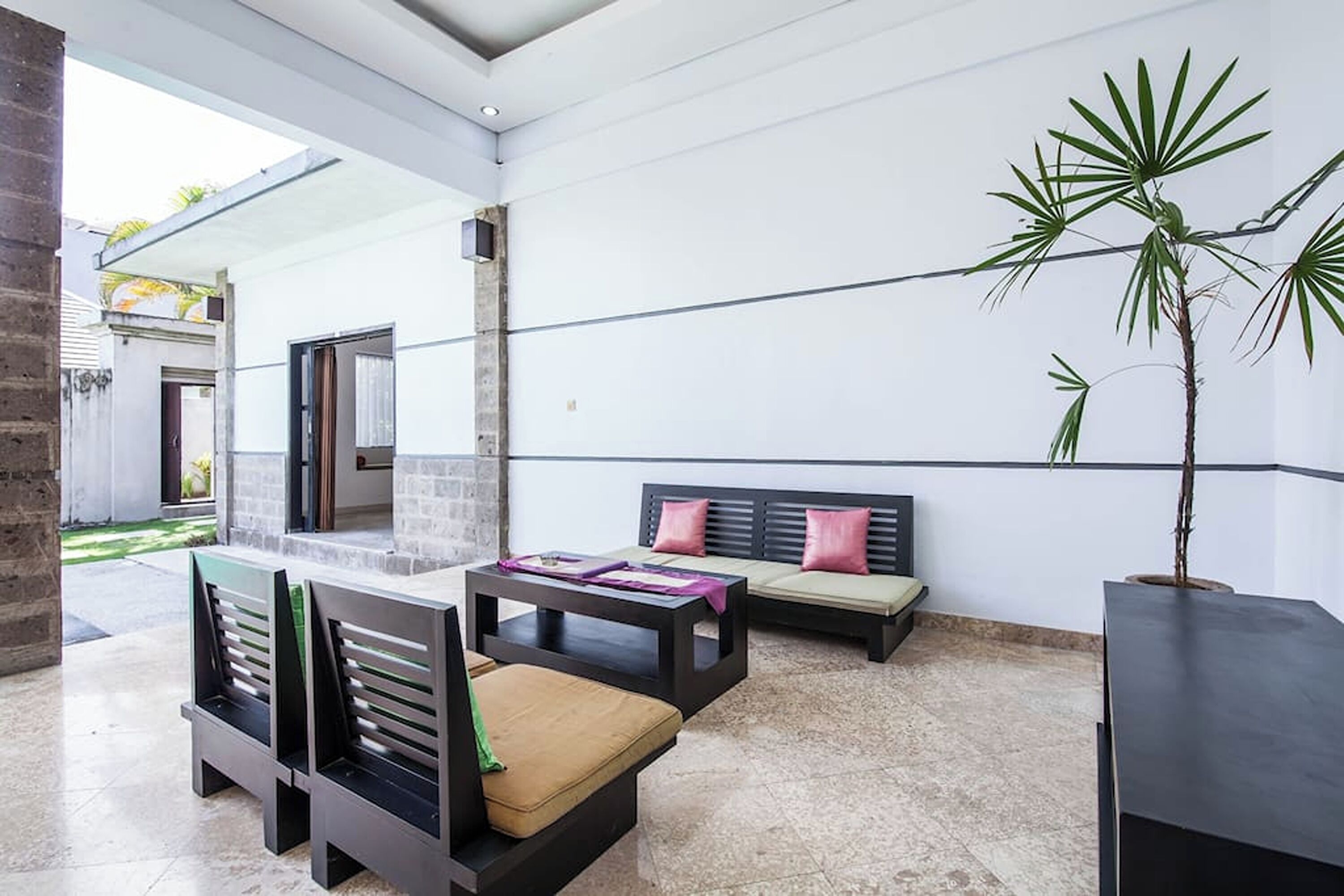 Un interior moderno con una zona de estar, un ventanal grande y una planta en maceta.