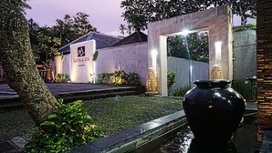 Una villa con un cartel que dice "Bali Mentai Villa" y una fuente ornamental al frente.