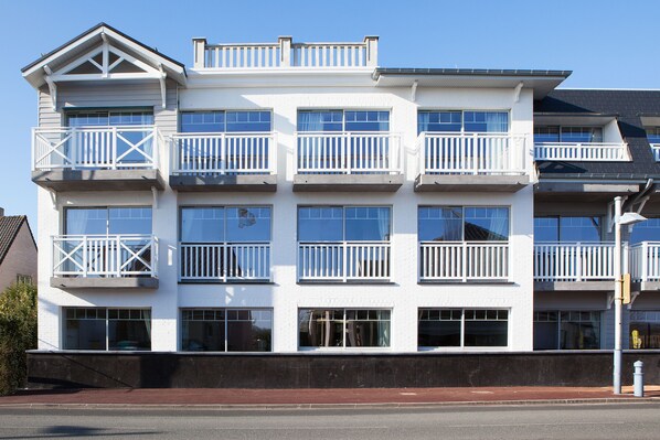 A multi-story building with balconies and large windows.