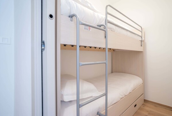 A bunk bed with a metal ladder, a wooden frame, and a white mattress. - Evancy La Brise des Dunes (Bray-Dunes)
