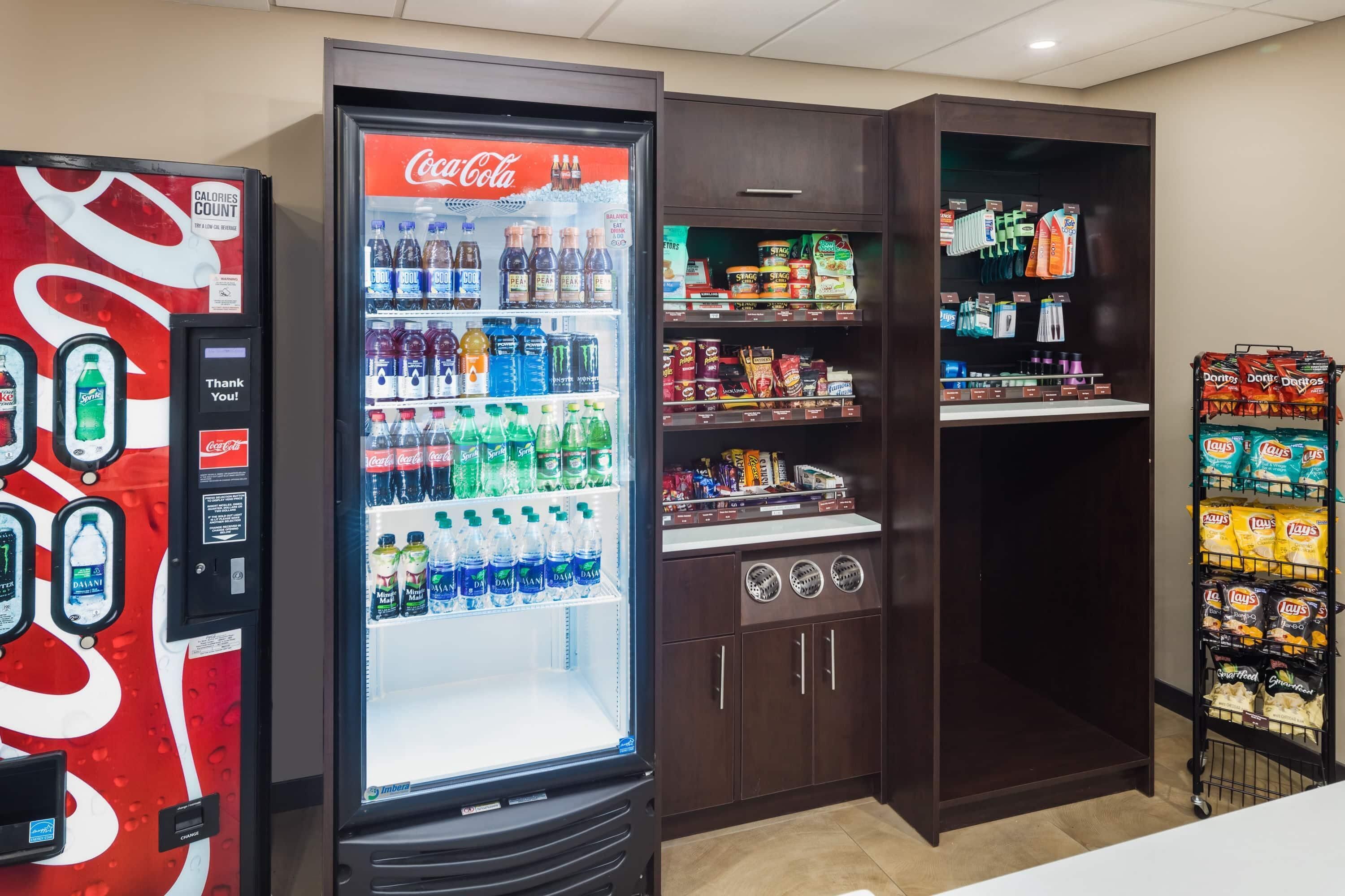 Máquina expendedora con logotipo de Coca-Cola, dispensador de agua y máquina expendedora de aperitivos.