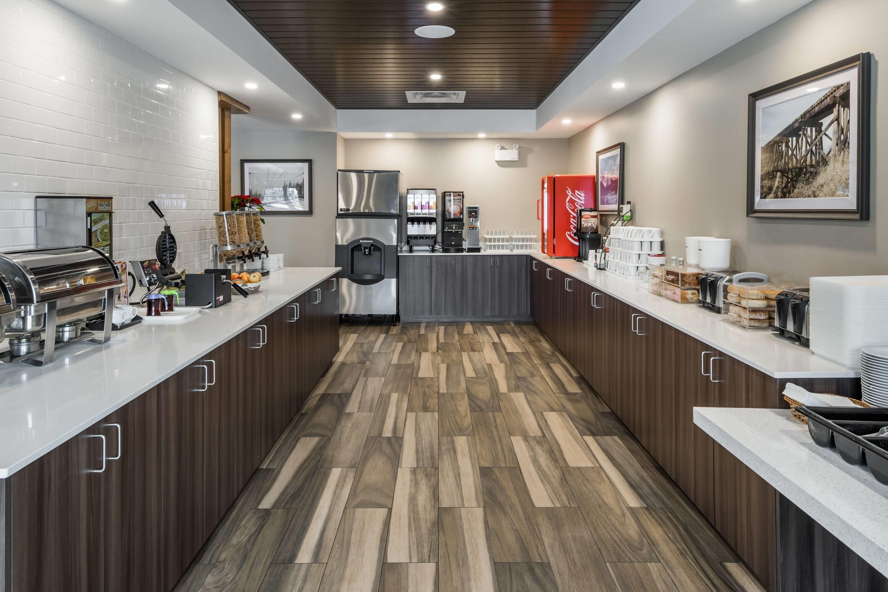 Een moderne keuken met een centraal eiland, roestvrijstalen apparatuur en een Coca-Cola koelkast.