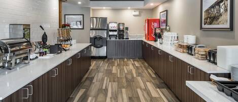 Uma cozinha moderna com uma ilha central, eletrodomésticos de aço inoxidável e uma geladeira Coca-Cola.